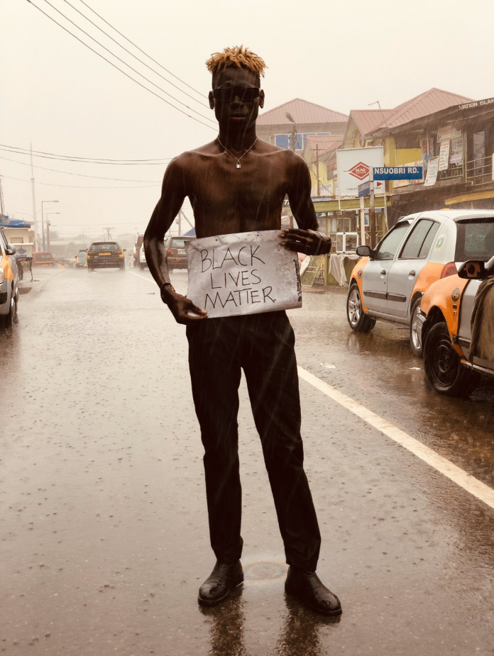A Ghanaian protesting in the rains